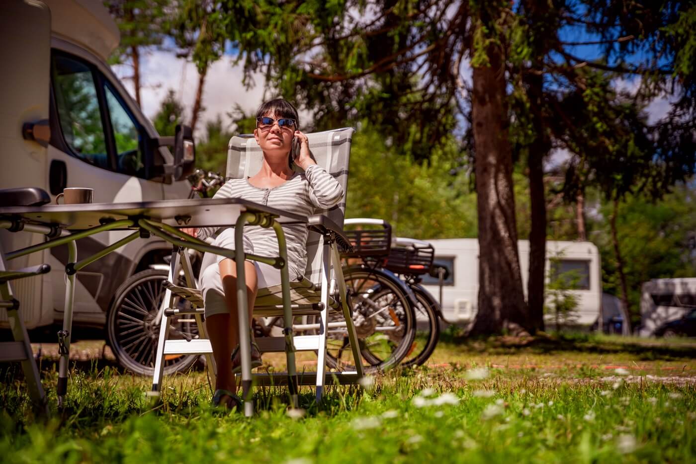 Femme parlant sur téléphone intelligent en plein air dans un camping.